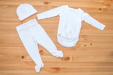 Clothes for newborn girl on a wooden background