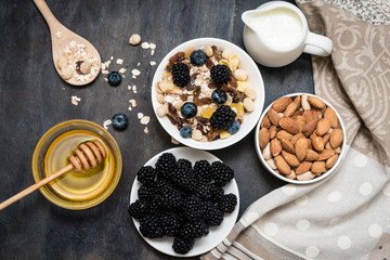 Delicious and healthy muesli in bowl with milk and bananas on dark wooden  table