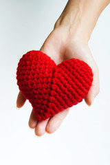 Woman hand holding red crocheted heart. Valentine's Day. Symbol of love.