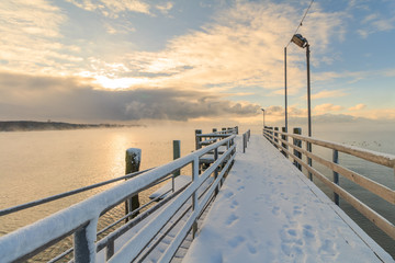 Fototapeta premium Molo przy Jeziornym Chiemsee przy wschodem słońca z mgłą na wodzie