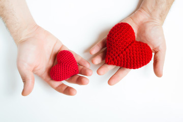 Man hands holding red crocheted hearts. Valentine's Day. Symbol of love.