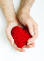 Man hands holding red crocheted hearts. Valentine's Day. Symbol of love.