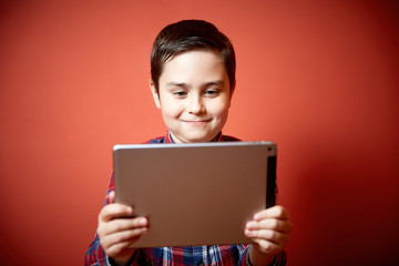 Naklejka premium cute boy playing tablet computer