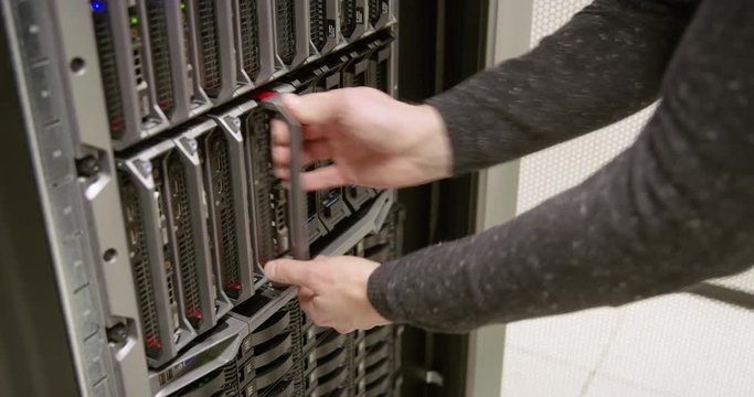 IT consultant repairing blade server in datacenter