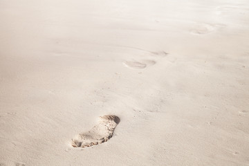 Footprints in white coastal sand