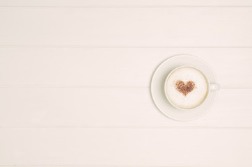 Coffee mug with heart love symbol on white wooden table top view