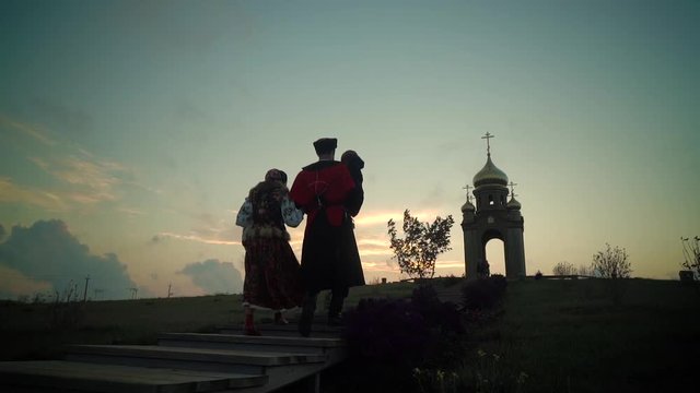 Family Cossacks in historical clothes went up the hill to the chapel