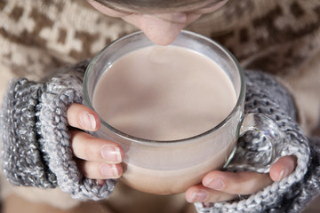 Hands in mittens hold cocoa