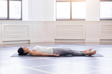 Young woman meditating on a wooden floor