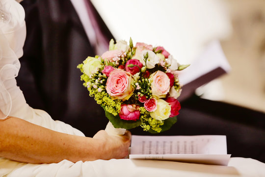 Hochzeitspaar mit Brautstrau&szlig; am Traualtar