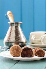 Homemade chocolate candies in cacao with cezve and coffee cups o