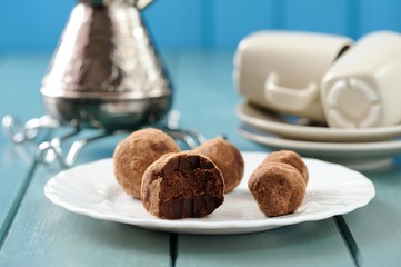 Homemade chocolate candies in cacao with cezve and coffee cups o