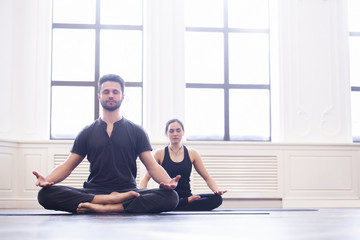 Fototapeta premium Group of young people doing yoga in the class