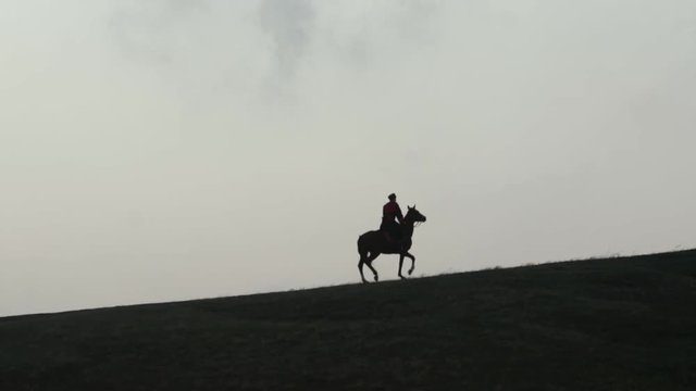 Cossack on horseback galloping over the hill