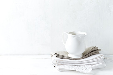 White ceramic milk jug on tea towels

