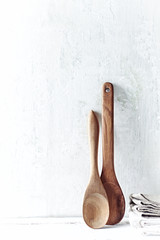 Two wooden spoons and kitchen towels

