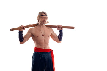 Actor Athlete man in trousers with naked torso practicing with wooden swords on a white background