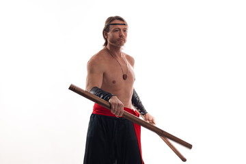 Actor Athlete man in trousers with naked torso practicing with wooden swords on a white background