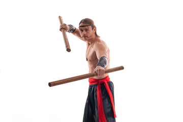 Actor Athlete man in trousers with naked torso practicing with wooden swords on a white background