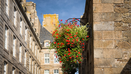 Pot with flowers suspended on the wall and the facades of Privateer's ancient House, Saint-Malo,...