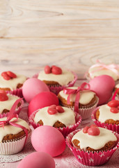 Easter cupcakes with white icing decorated with pink candy and r