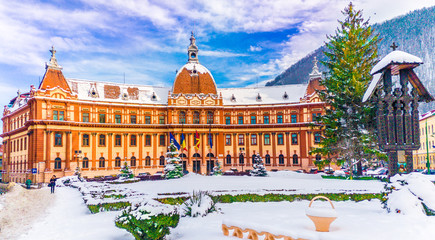 Obraz premium Prefecture building, park and cross monument in winter season, Brasov, Transylvania, Romania