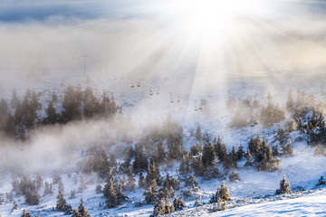Sun over winter mountains, covered with snow.