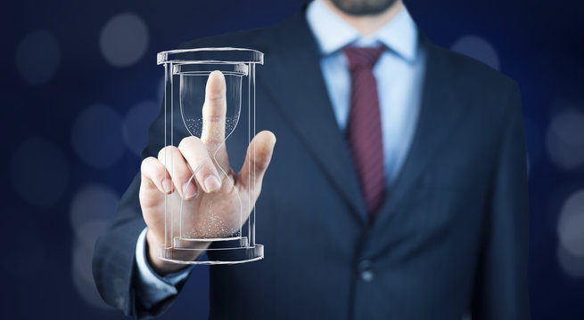 Man's hand holding hourglass sand - Powered by Adobe