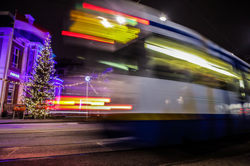 Fototapeta premium AMSTERDAM, NETHERLANDS - JANUARY 09, 2017: Blurred silhouette of moving tram in Amsterdam city at night. January 09, 2017 in Amsterdam - Netherland.