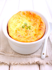 Cottage cheese casserole in white dish decorated with mint, on a white wooden background. Selective focus.