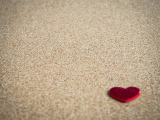 Red heart on cork board.