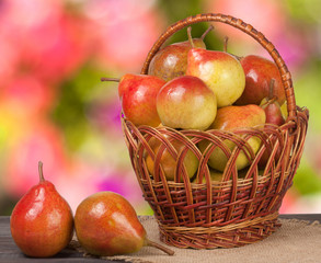 pears in a wicker basket on wooden table with blurred background
