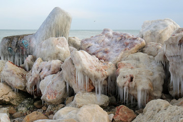 Обледеневшие камни на берегу моря зимой