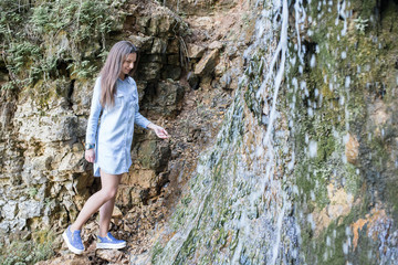 Naklejka premium woman walking near the mountain waterfalls