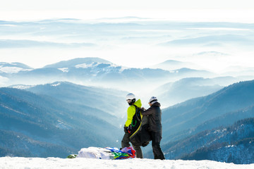 Paragliders getting ready to launch from snowy slope of a mounta