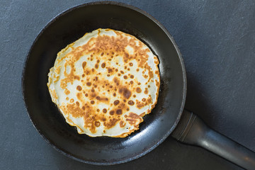 Stack of pancakes on frying pan.