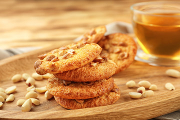 Peanut cookies with nuts and tea on wooden plate,closeup