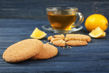 Delicious lemon cookies with green tea on wooden table