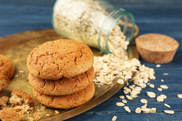 Diet cookies with oatmeal on tray, wooden background