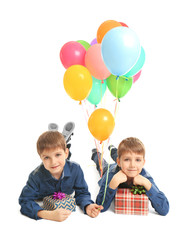 Fototapeta na wymiar Cute little boys with presents and colorful balloons on white background