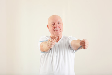 Senior man training with stretching band in rehabilitation center