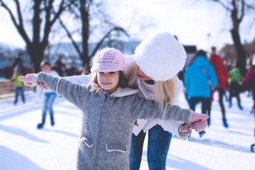 Mother and daughter skating on ice