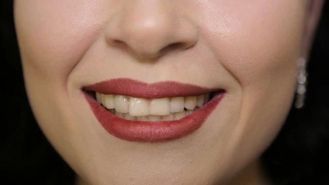 She laughs at the camera. Face close-up.