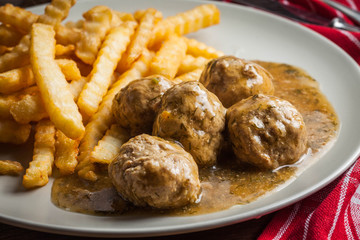 Meatballs with french fries in dill sauce.