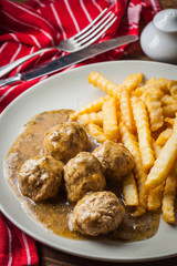 Meatballs with french fries in dill sauce.