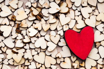 Wooden hearts, one red heart on the heart background.