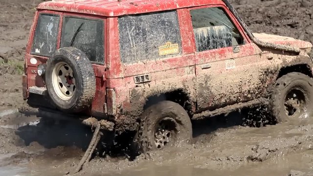 4x4 offroad vehicle is trying to cross the muddy area 