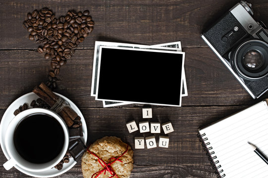 Fototapeta i love you inscription with coffee cup, retro camera blank photo and notebook