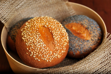 still life focused on bun with sesame seeds in basket.