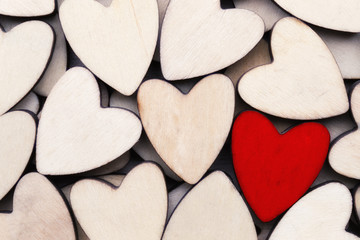 Wooden hearts, one red heart on the heart background.